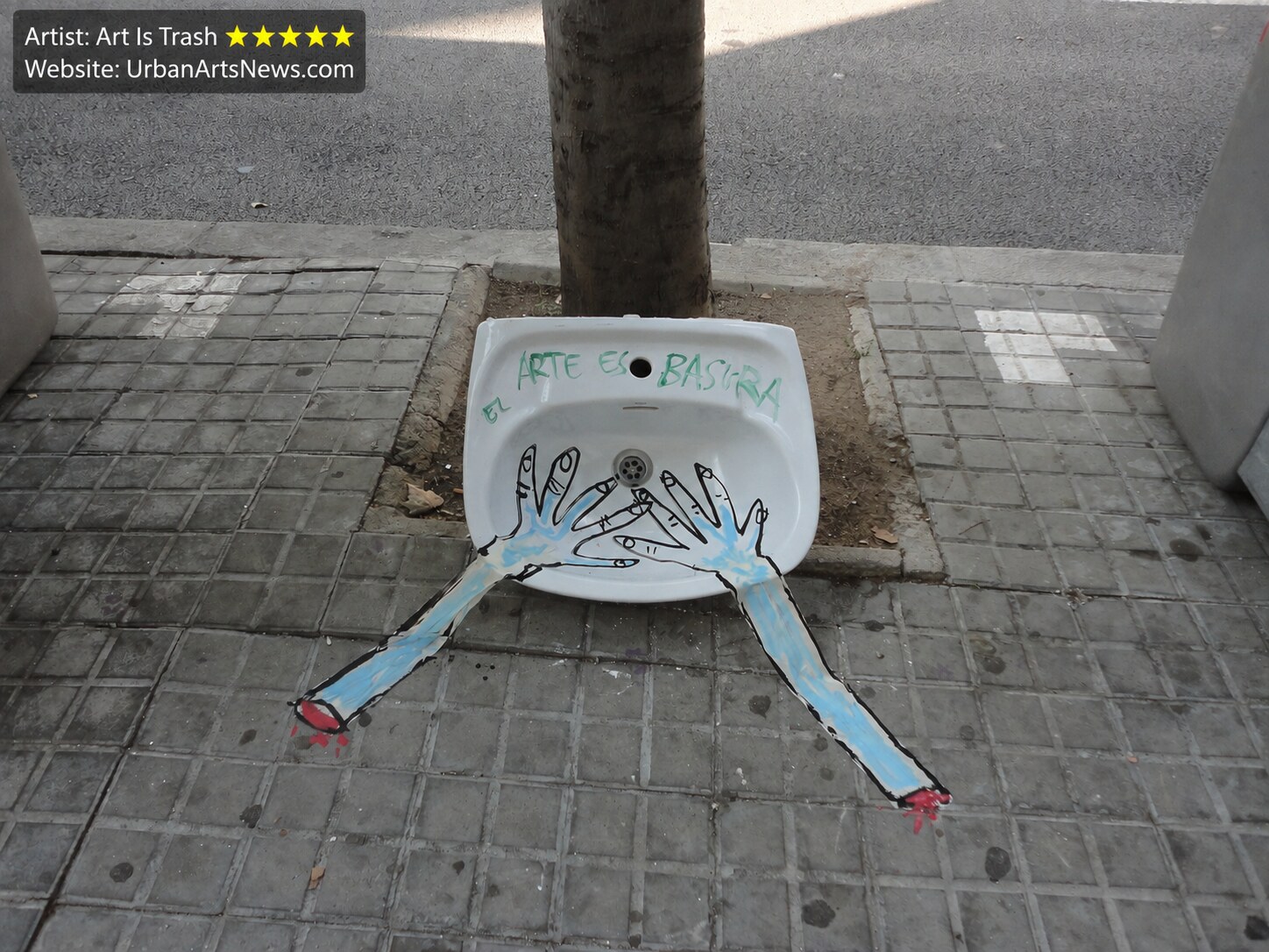 Art Is Trash Barcelona urban art: A discarded sink animated with painted figures by Art Is Trash on a Barcelona pavement.