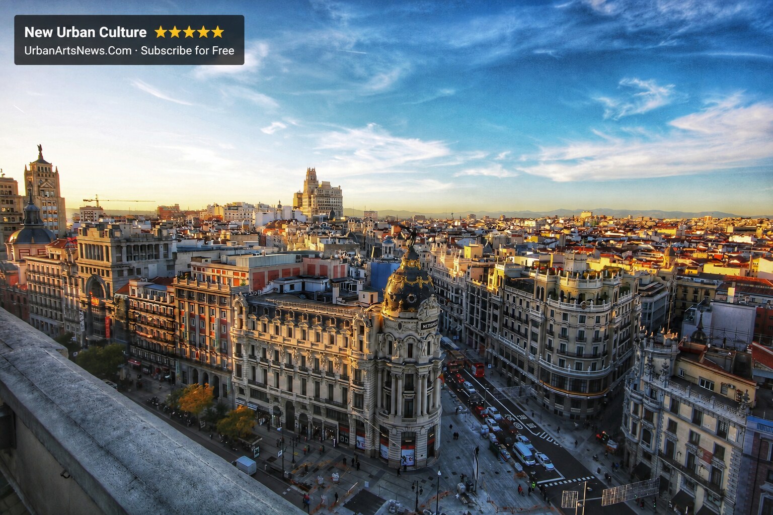 Gran Via and central Barcelona architecture at golden hour with Urban Arts News branding