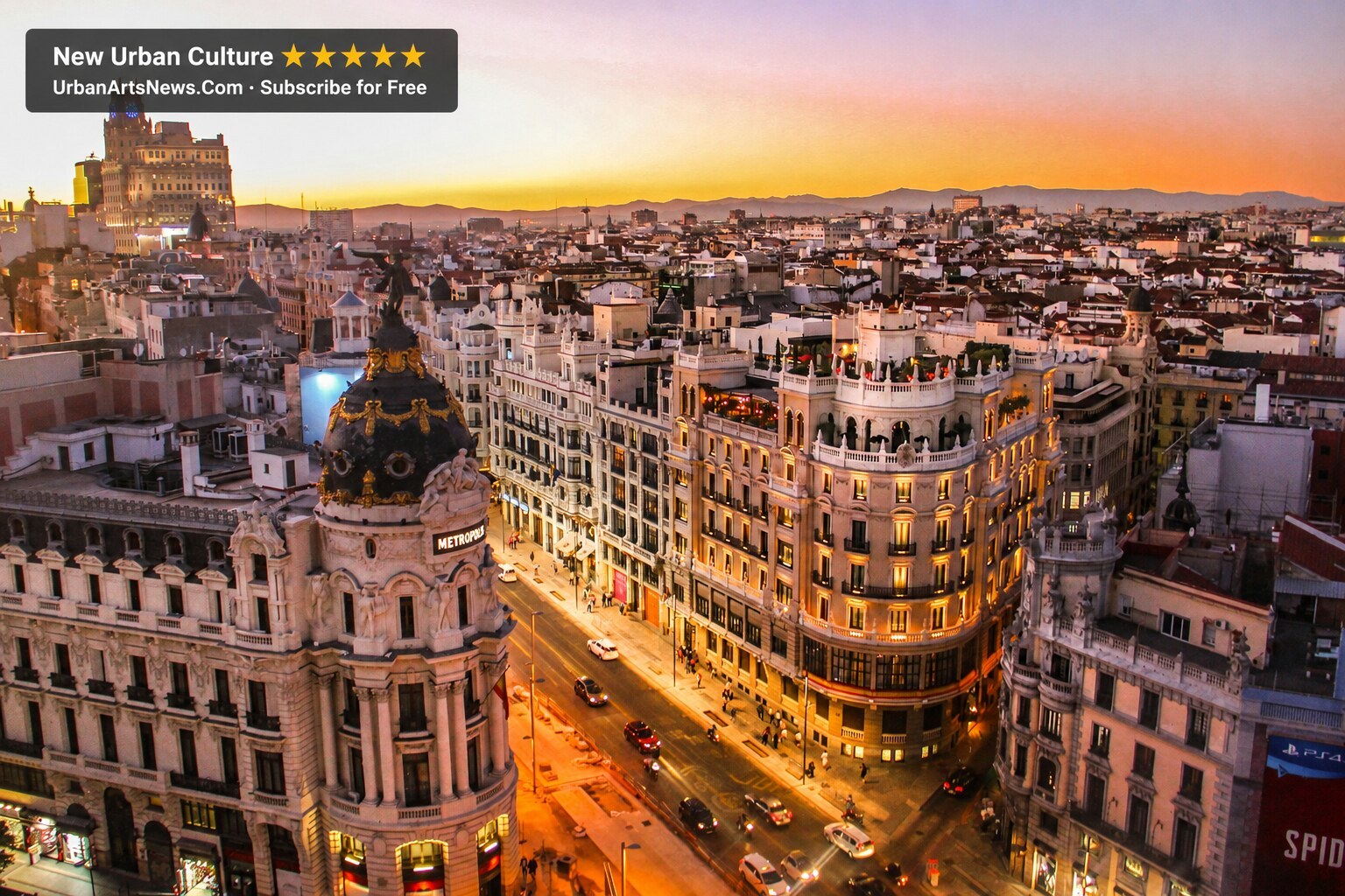 Illuminated Gran Via Barcelona at night with Urban Arts News branding