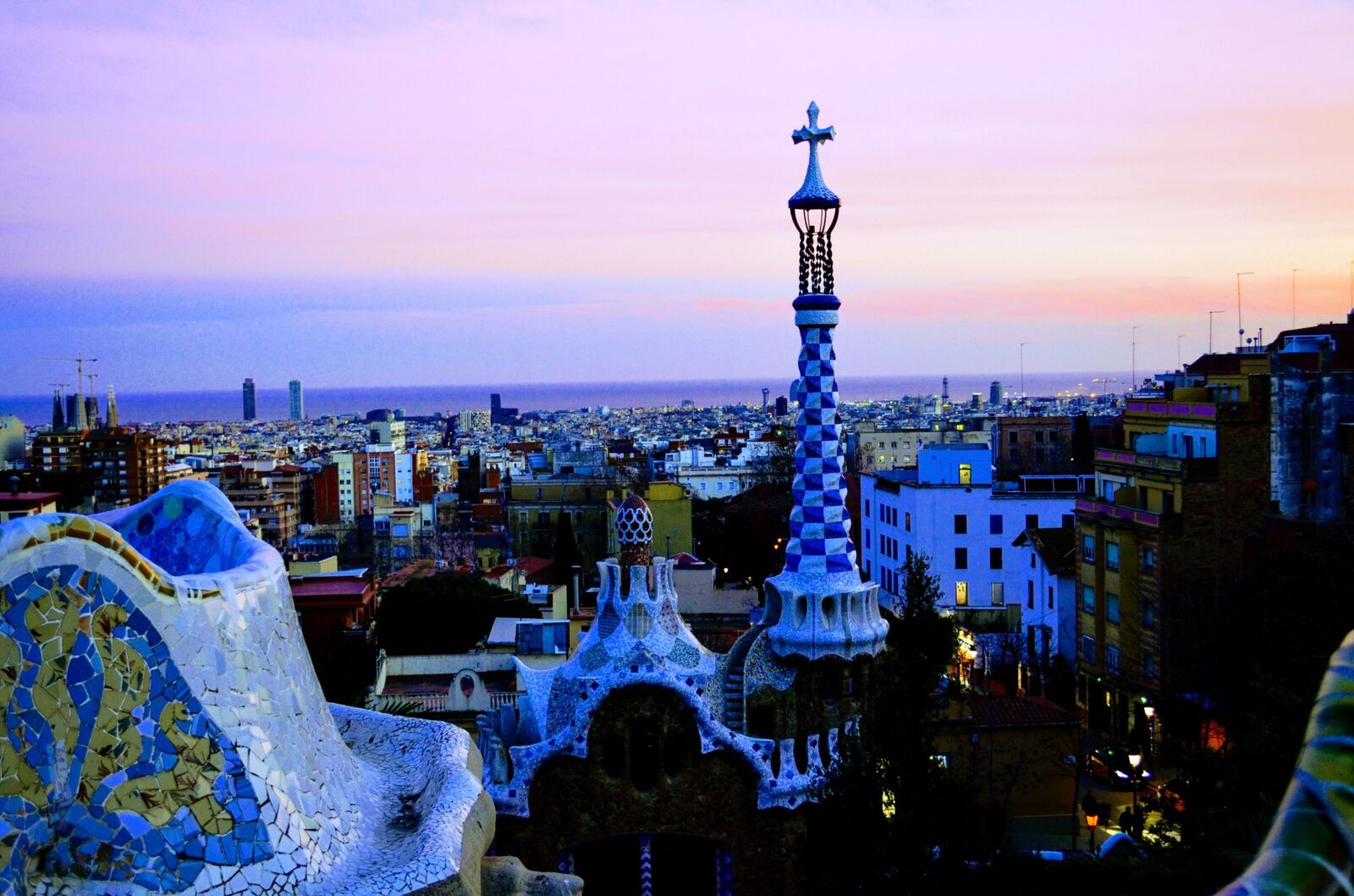 Park Güell architecture and Barcelona skyline at sunset