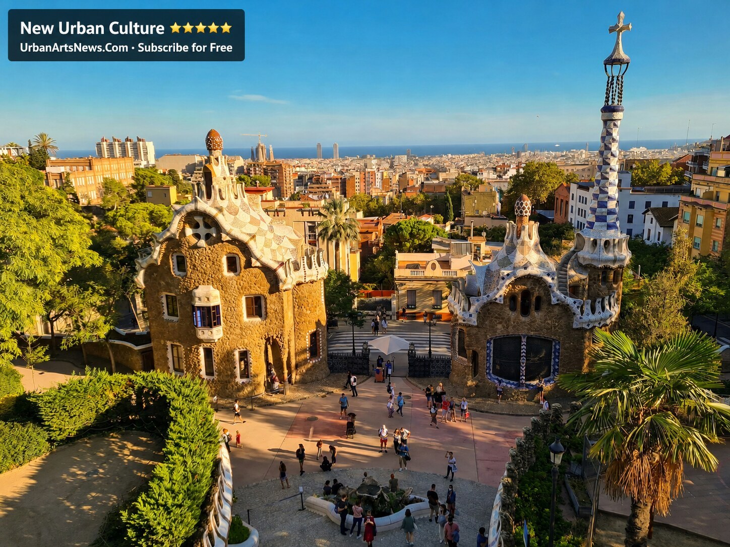 Park Güell entrance buildings overlooking Barcelona with Urban Arts News branding