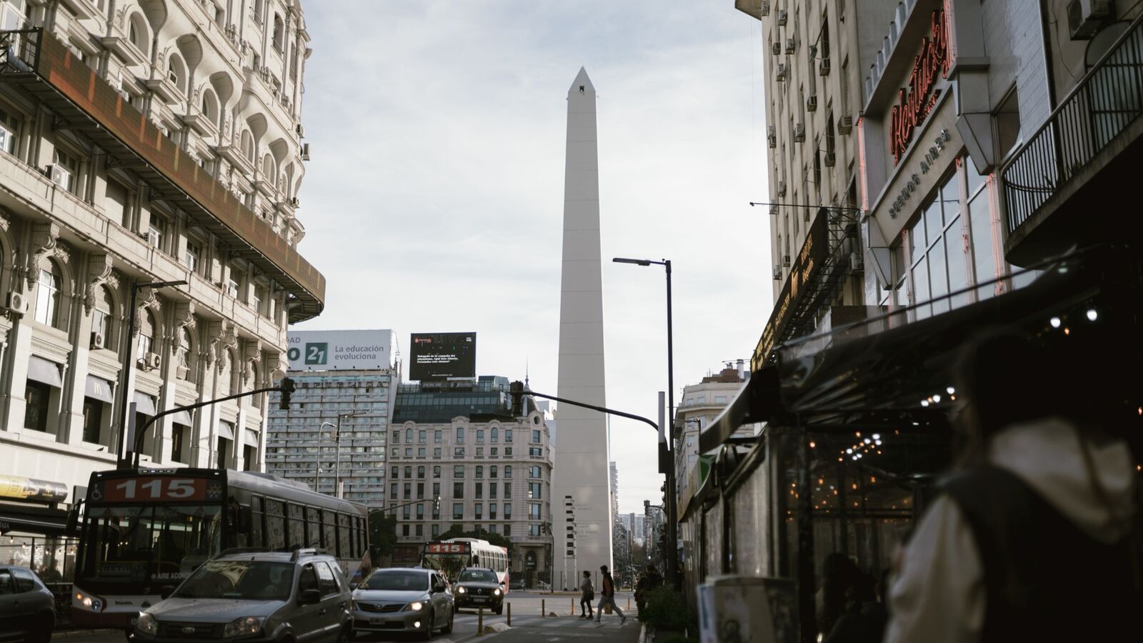 Obelisk of Buenos Aires above traffic on a city avenue