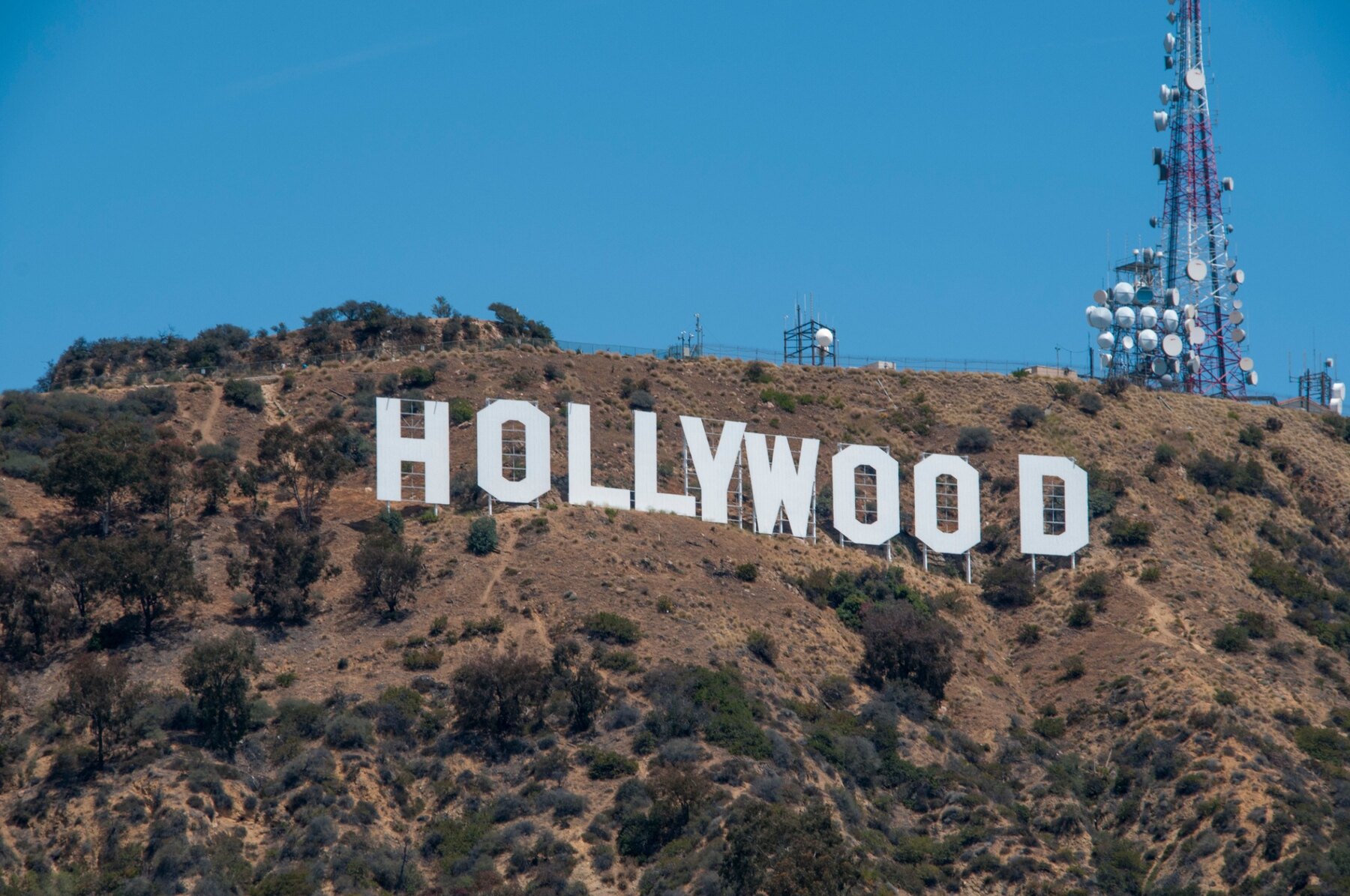 Hollywood Sign and radio towers beneath a blue Los Angeles sky