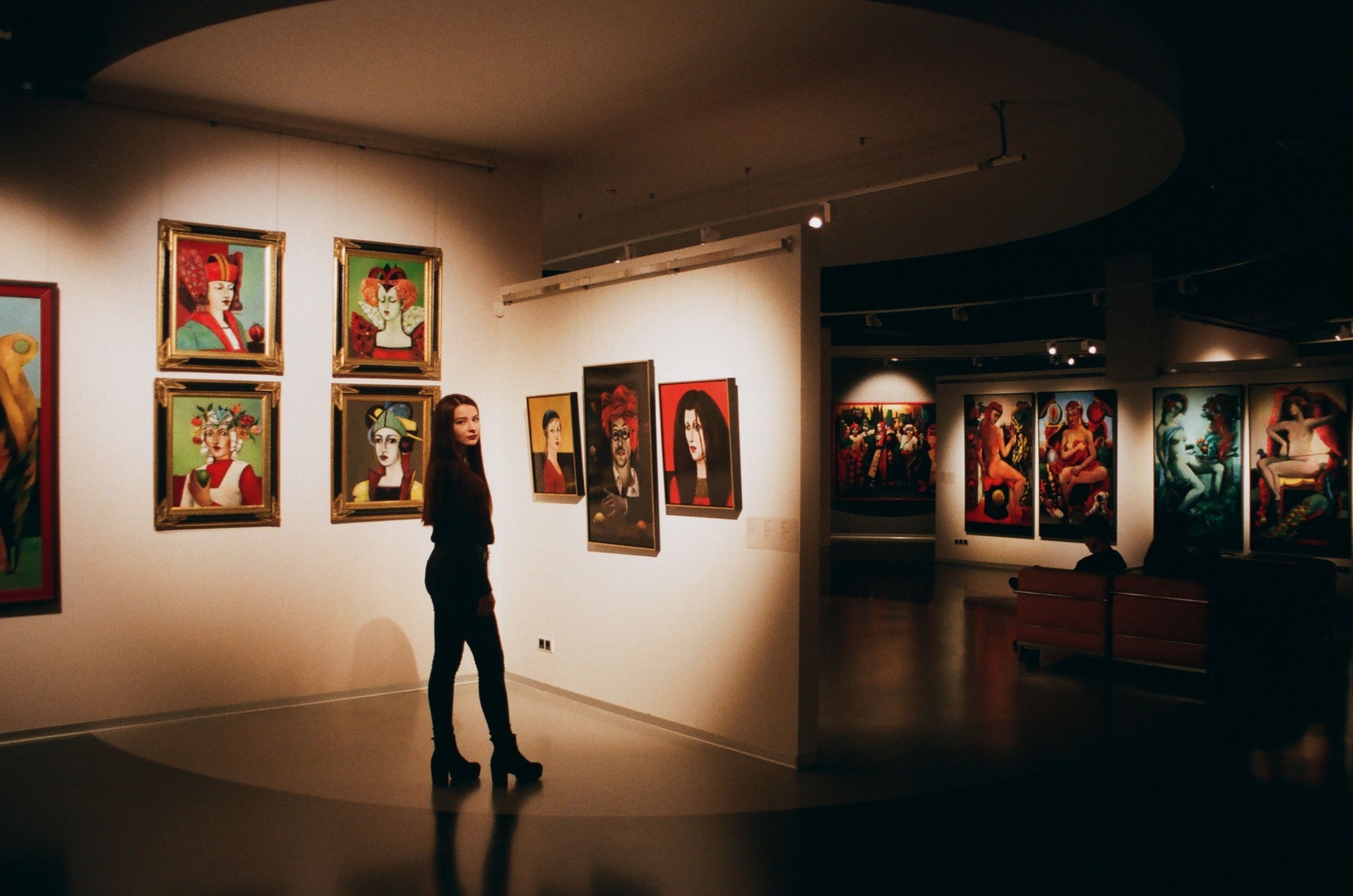 Visitor viewing expressive paintings in a curated urban art gallery