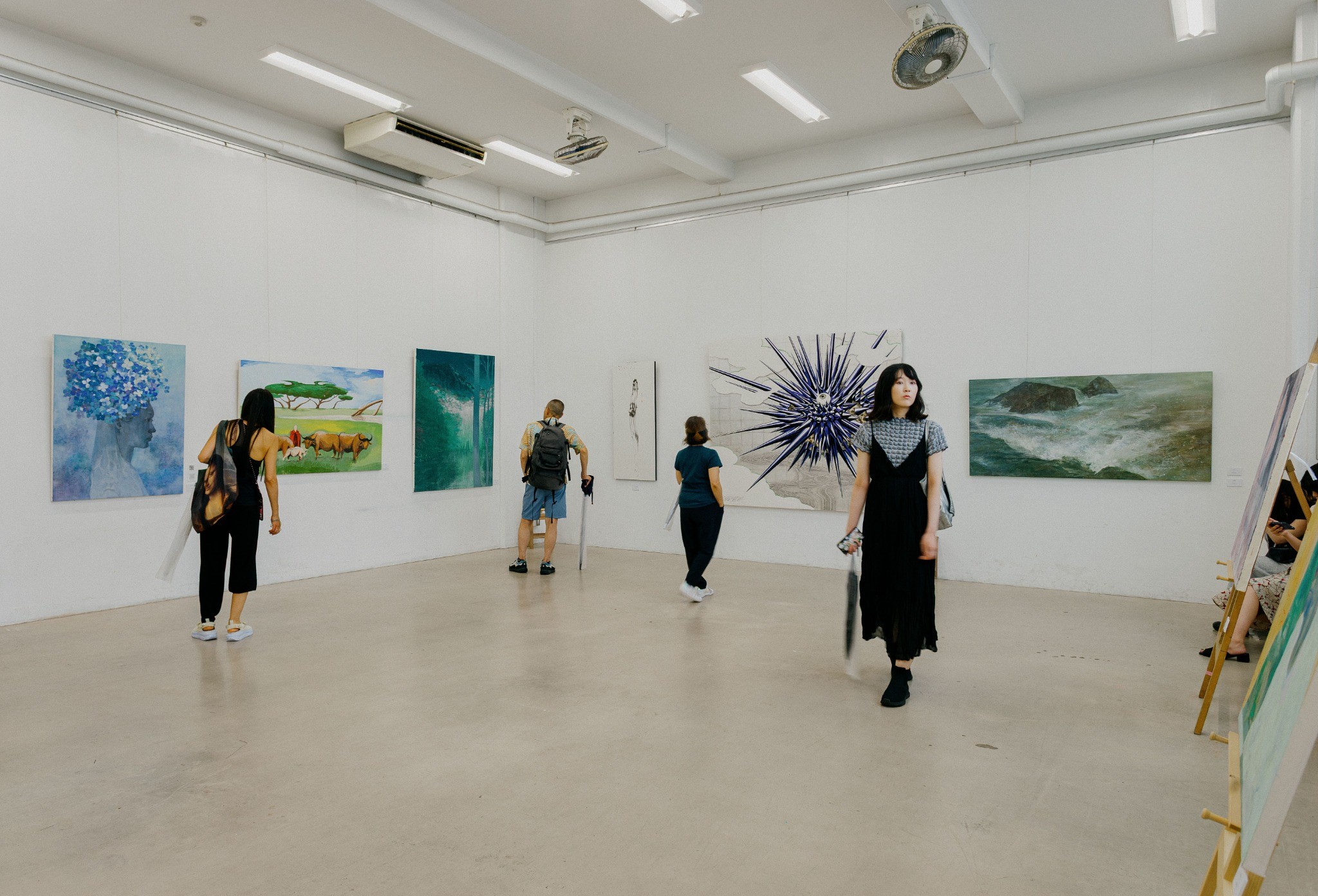 Independent contemporary urban art gallery with visitors and paintings